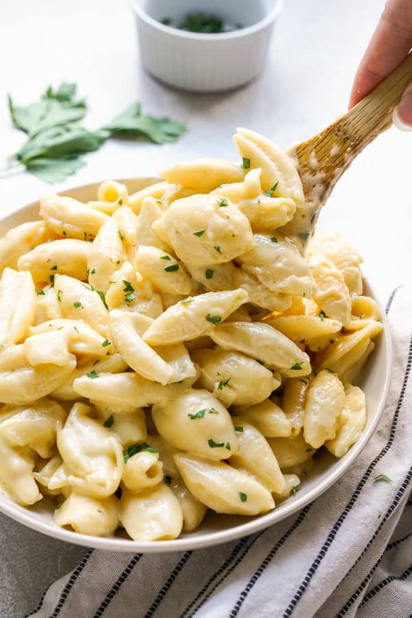 Using a wooden spoon to scoop out some mac and cheese