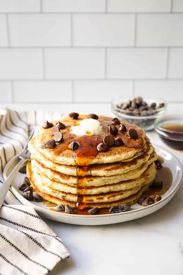 A stack of chocolate chip pancake with syrup on it
