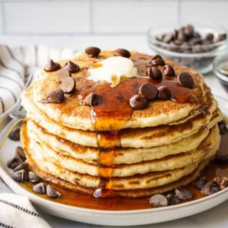 A stack of chocolate chip pancake with maple syrup