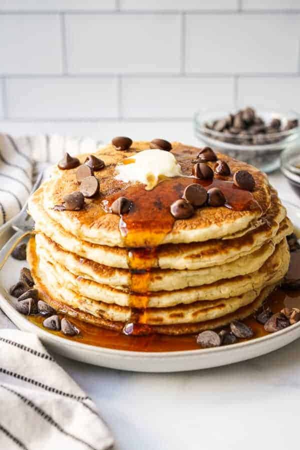 A stack of chocolate chip pancake with maple syrup