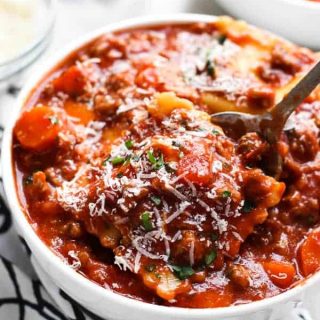 LIfting up a ravioli from Ravioli Beef Soup with a spoon