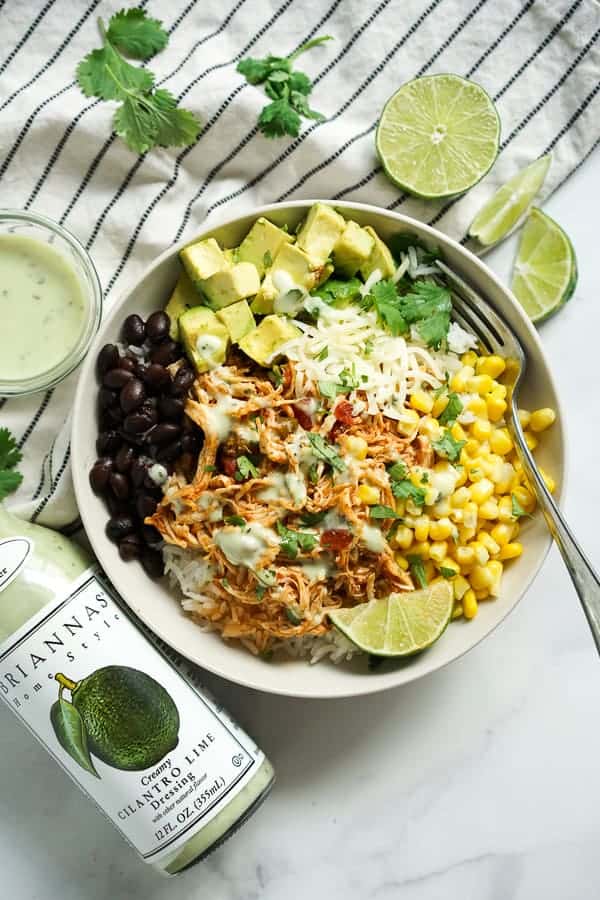 A bowl of Slow Cooker Chicken Burrito Bowl with BRIANNAS dressing on the side