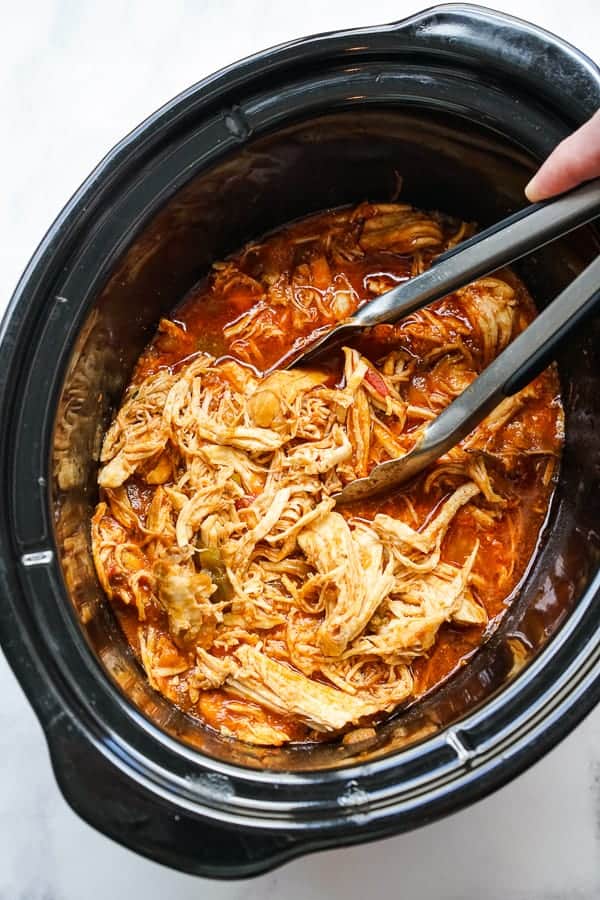 Shredding chicken in a crockpot using a pair of tongs