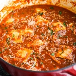 A large pot of Ravioli soup in thick tomato beef broth