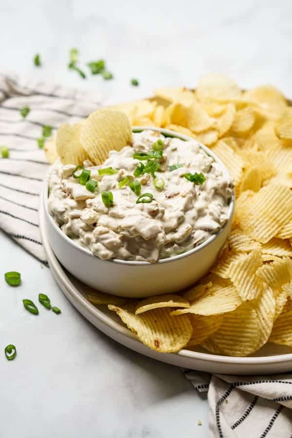 A bowl of caramelized onion dip with potato chips