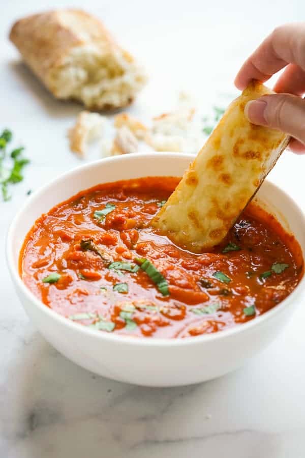 Dipping cheesy toast into tomato soup