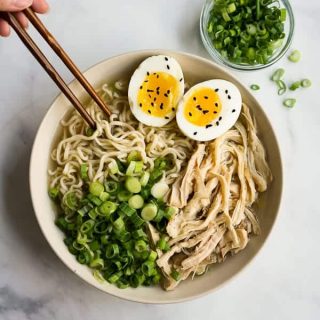 Chopsticks picking up noodles from a bowl of Instant Pot Ramen Noodles