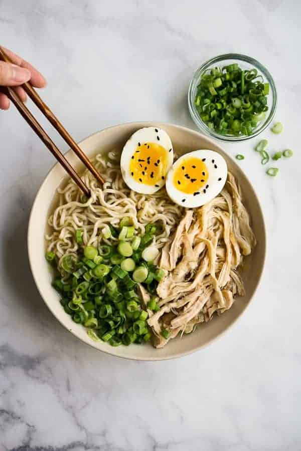 Chopsticks picking up noodles from a bowl of Instant Pot Ramen Noodles