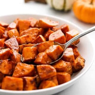A bowl of sweet potatoes with a spoon