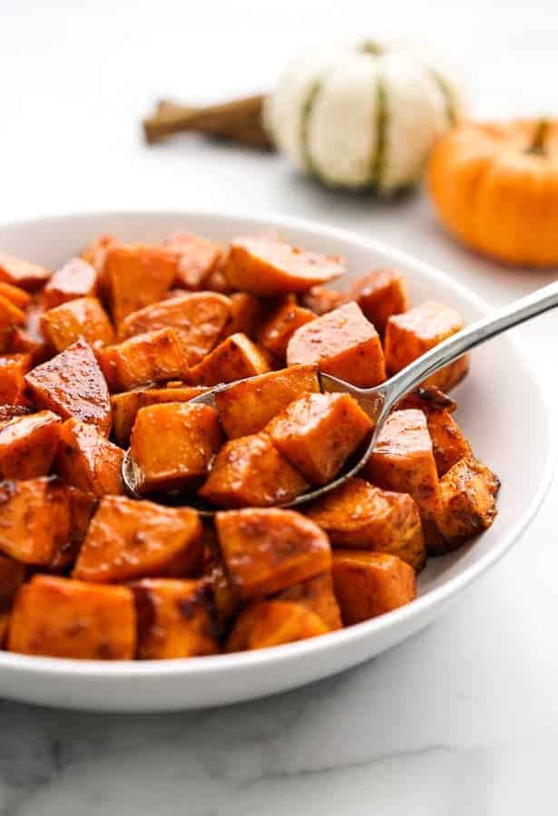 A bowl of sweet potatoes with a spoon