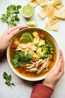 Two hands holding onto a bowl of Instant Pot Chicken Tortilla Soup