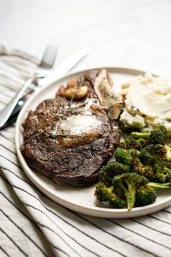 A plate of steak with broccoli and mashed potatoes