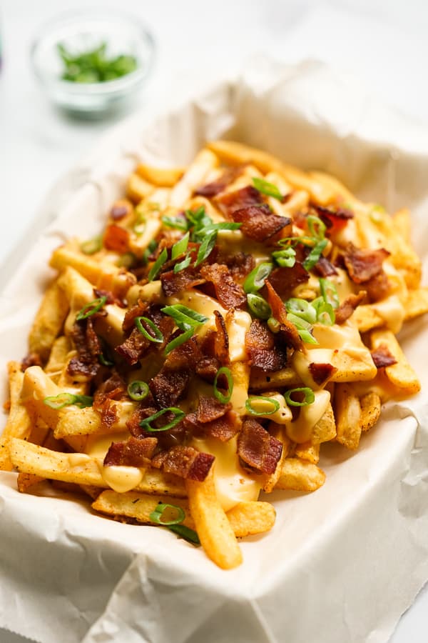 A rectangular plate of Baked Cajun Fries with Cheese Sauce