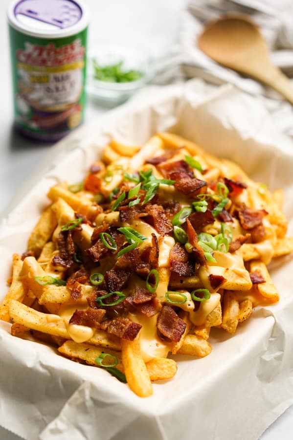 Baked Cajun Fries with Cheese Sauce with Tony Chachere's seasoning in the background