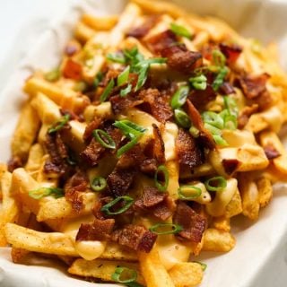 Closeup of a plate of Baked Cajun Fries with Cheese Sauce