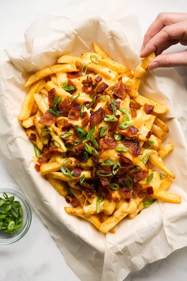 Hand grabbing a piece of Baked Cajun Fries