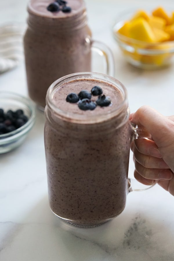 Hand grabbing a glass of smoothie