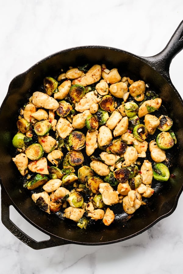 Sauteing Brussels sprouts and chicken on a cast iron skillet