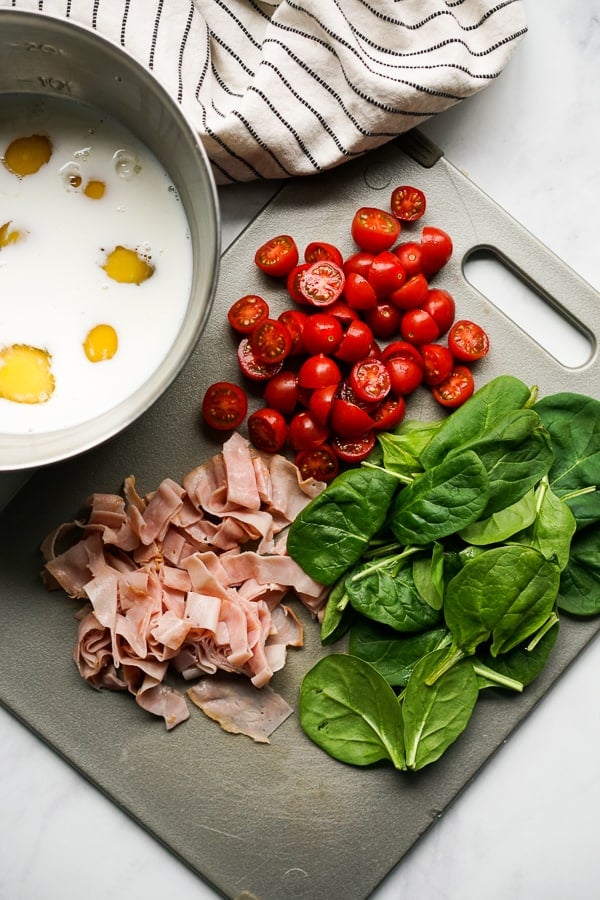 Eggs and milk mixture, cherry tomatoes, ham and spinach