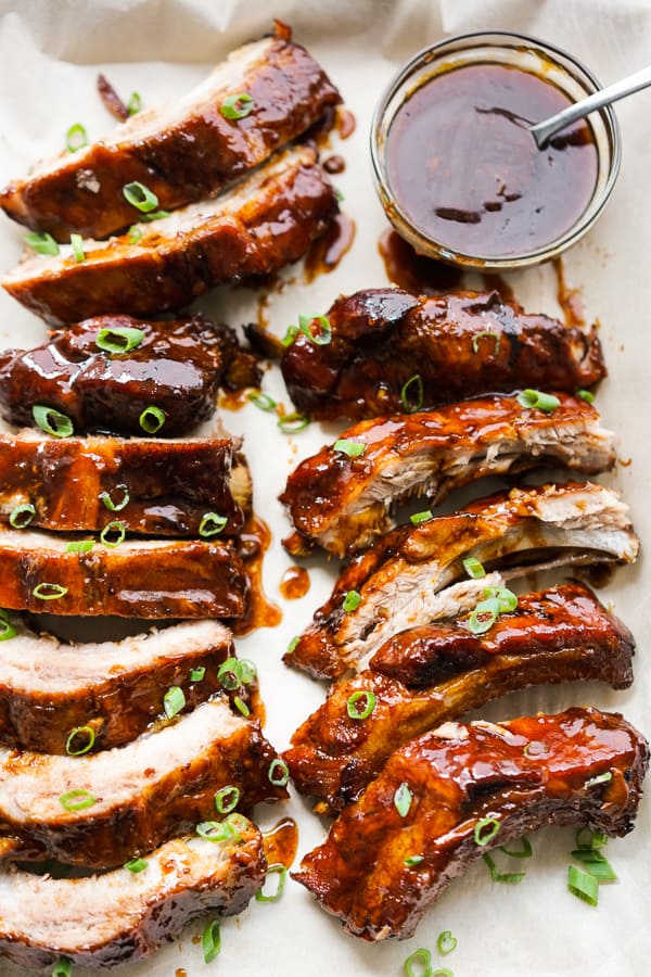 Ribs cut into smaller pieces with sauce in the background