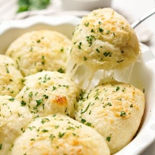 Pulling out a Cheesy Garlic Roll from the pan