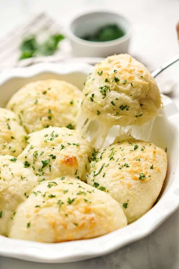 Pulling out a Cheesy Garlic Roll from the pan