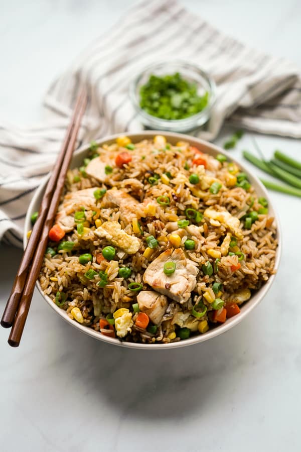 Fried rice with chicken in a bowl, with chopsticks on the bowl