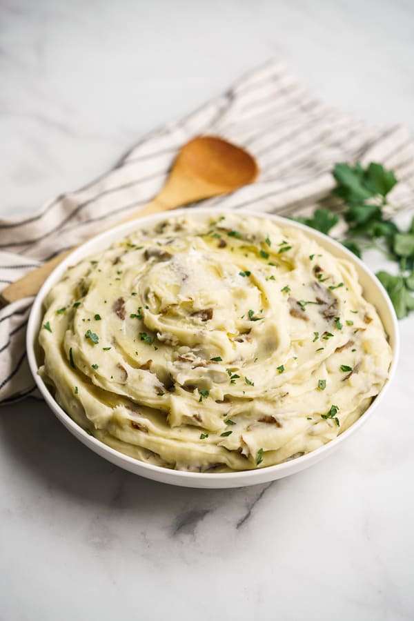 Instant Pot Garlic Mashed Potatoes in a bowl with a wooden spoon in the background