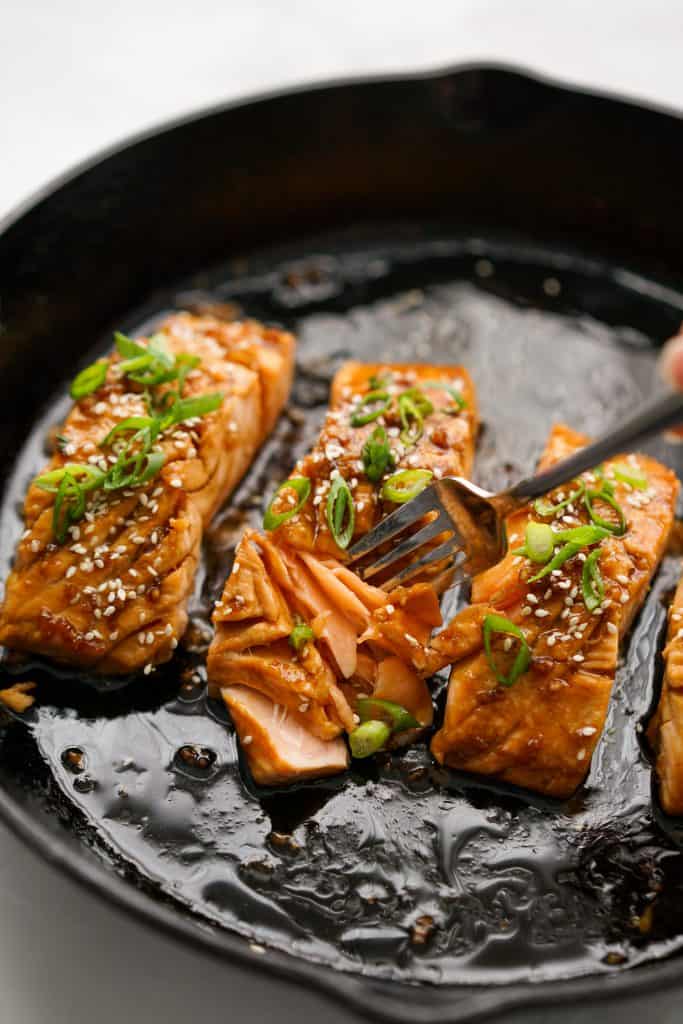 Cutting into a piece of pan fried teriyaki glaze salmon