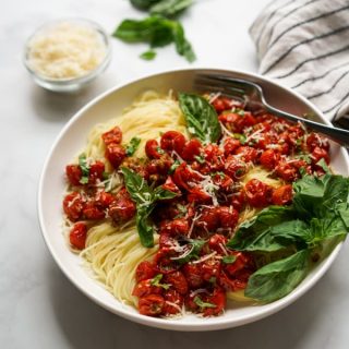 A bowl of angel hair pasta with roasted cherry tomatoes