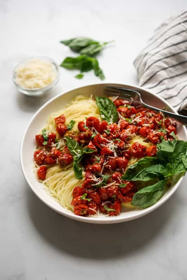 A bowl of angel hair pasta with roasted cherry tomatoes