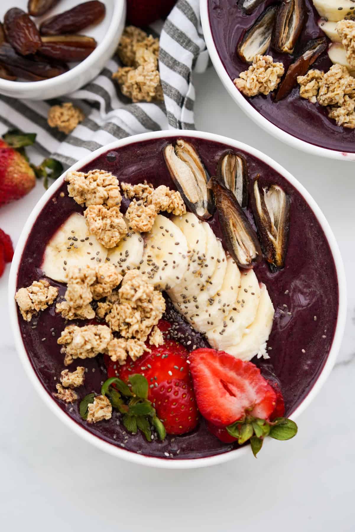 Top down view of Acai Smoothie Bowl topped with strawberries, bananas, dates and granola