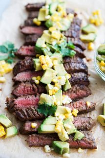 Steak sliced in strips topped with avocado corn topping