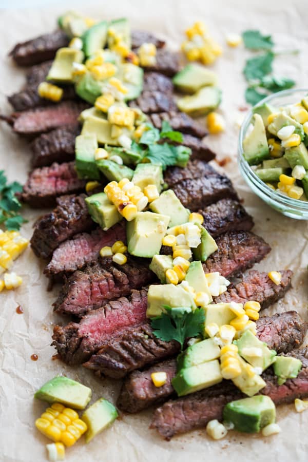 Sliced steak with avocado and corn topping