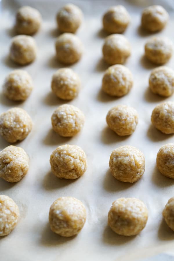 Uncooked chicken meatballs lined on a tray