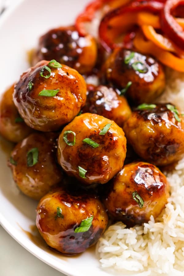 Closeup of chicken mealballs coated with sticky sweet and sour sauce