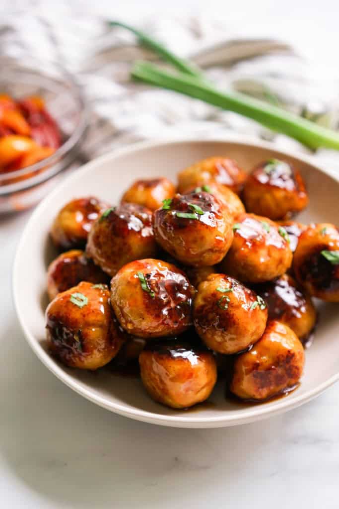 A bowl loaded with sweet and sour meatballs