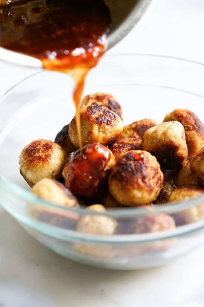 Adding sweet and sour sauce to meatballs