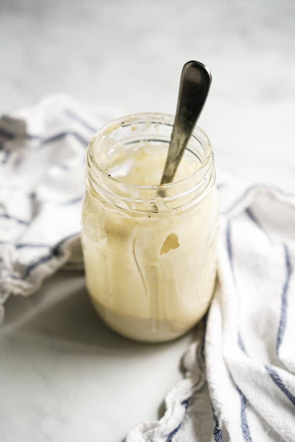 A mason jar of homemade creamy caesar dressing