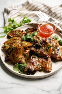 A plate of Thai Grilled Chicken garnished with chopped cilantro