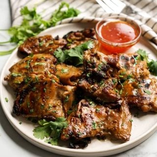 A plate of Thai Grilled Chicken garnished with chopped cilantro