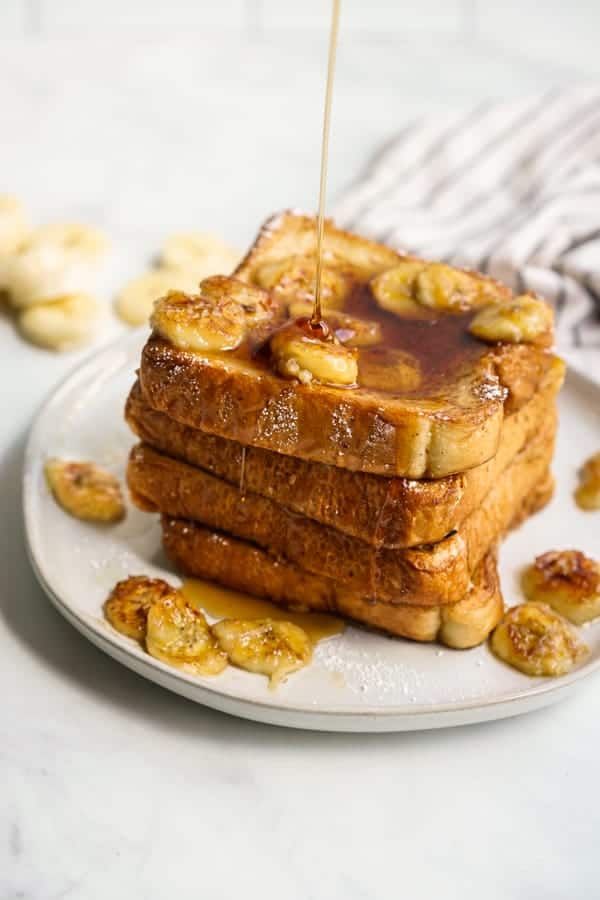 Drizzling maple syrup onto a stack of french toast