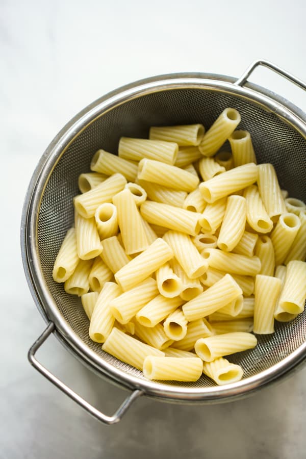 Cooked rigatoni pasta in round colander 