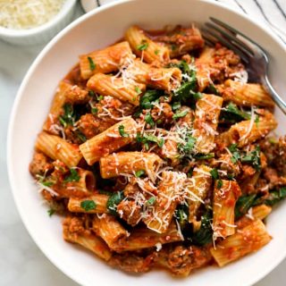 Closeup view of Creamy Tomato Pasta tossed with Italian sausage, spinach, parmesan and parsley