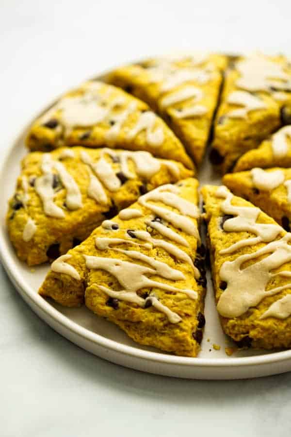 A plate of triangular pumpkin chocolate chip scones.