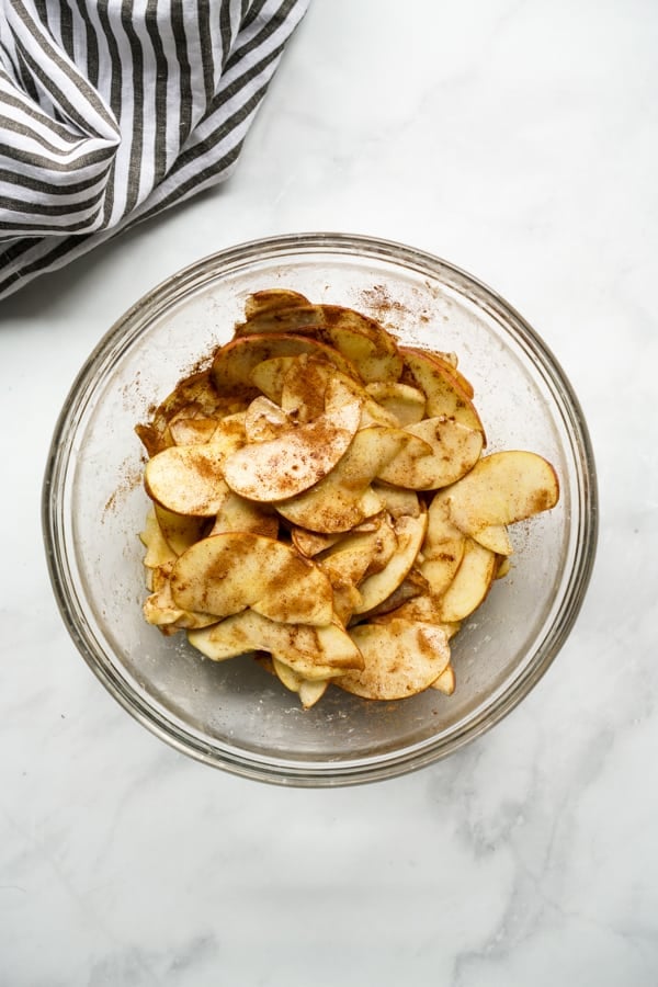 Apple slices, brown sugar, cinnamon, lemon juice, maple syrup and flour in a mixing bowl
