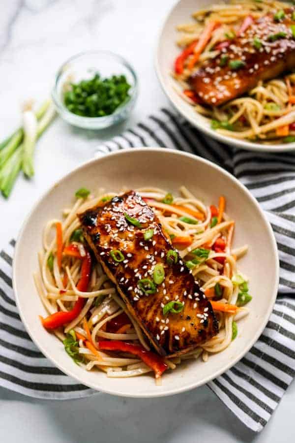 Two bowls of rice noodles topped with Orange Ginger Salmon
