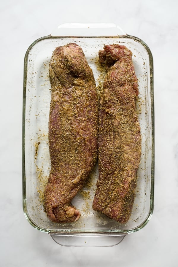 Raw pork tenderloins covered in herbs and spices