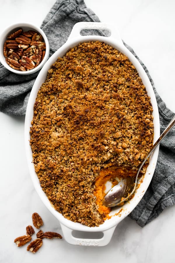 A large rectangular casserole dish of mashed sweet potatoes topped with pecan crumble