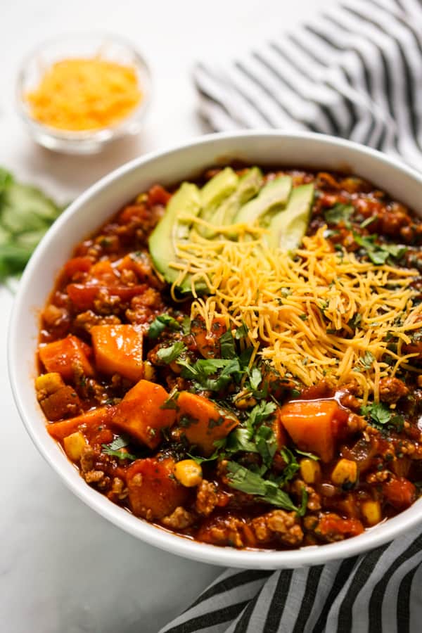 A bowl of tomato based chili with ground turkey and sweet potatoes.